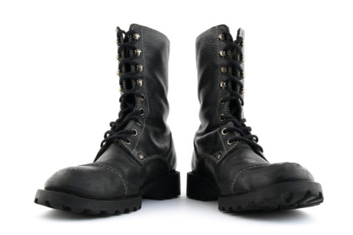 Military style black leather boots on white background.